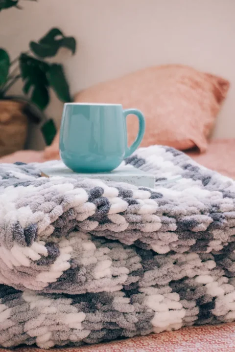 A blue coffee mug on a folded beach towel