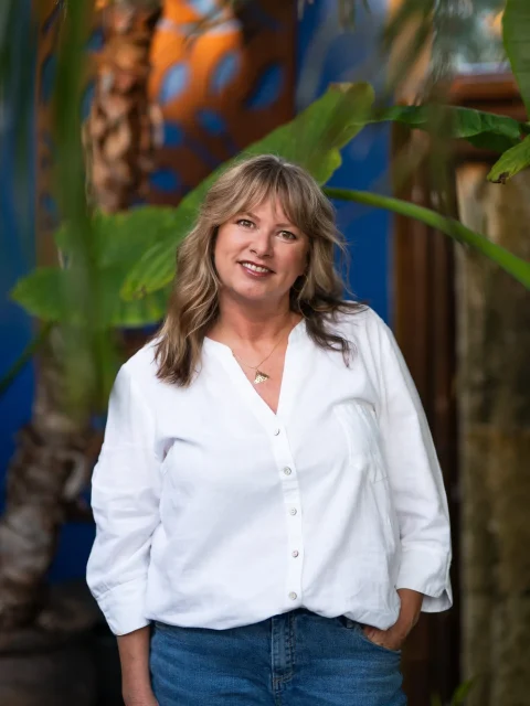 Kimberley in a white blouse with a tropical background