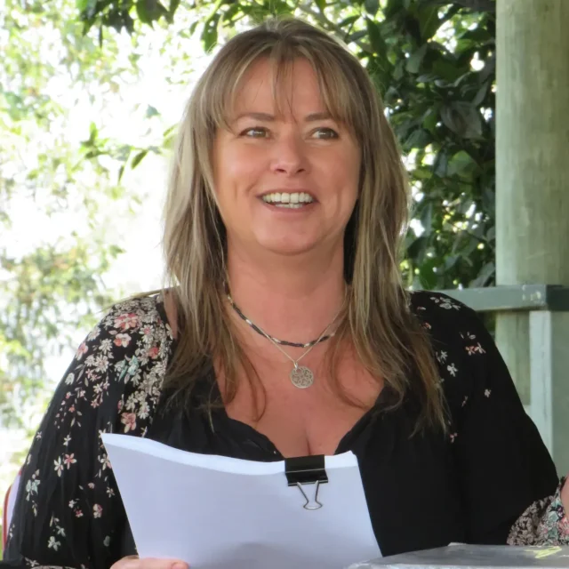 Kimberley in an outdoor setting holding course material.