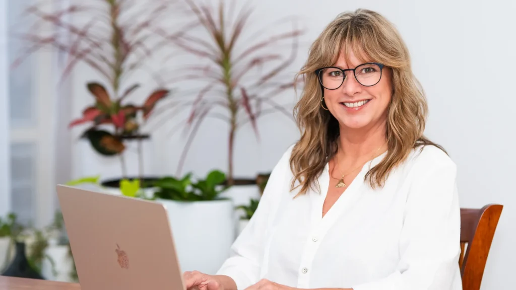 Kimberley sitting at her desk, working on her laptop.